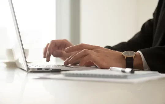 close-up-image-mans-hands-wristwatch-typing-laptop@2x